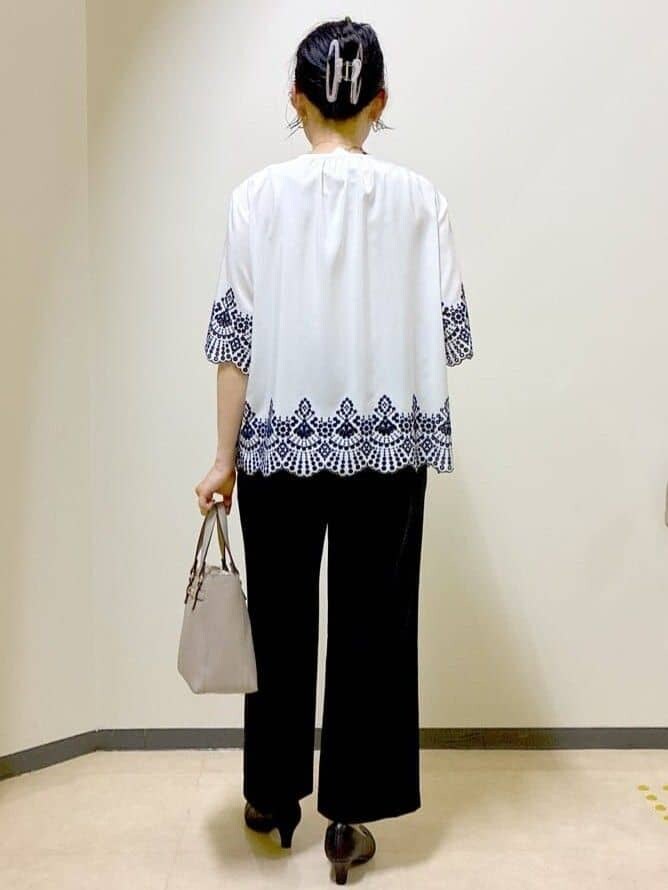 ホワイト系のシャツ/ブラウス、ブラック系のその他パンツ、ベージュ系のハンドバッグを着用したレディースの夏コーディネートの3枚目の写真