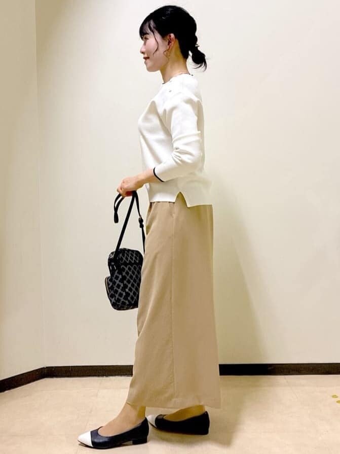 ホワイト系のニット/セーター、イエロー系のその他パンツ、ブルー系のショルダーバッグを着用したレディースの春コーディネートの2枚目の写真