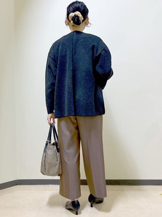 グレー系のノーカラーコート、ホワイト系のニット/セーター、ブラウン系のその他パンツを着用したレディースの冬コーディネートの3枚目の写真