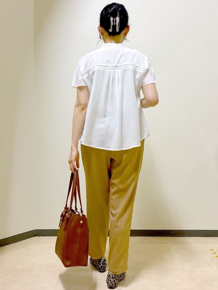 ホワイト系のシャツ/ブラウス、イエロー系のその他パンツ、ブラウン系のトートバッグを着用したレディースの秋コーディネートの3枚目の写真