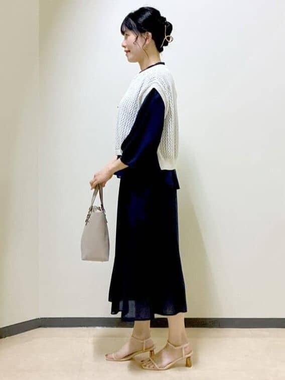 ブルー系のシャツ/ブラウス、ブルー系のスカート、ベージュ系のニット/セーターを着用したレディースの夏コーディネートの2枚目の写真