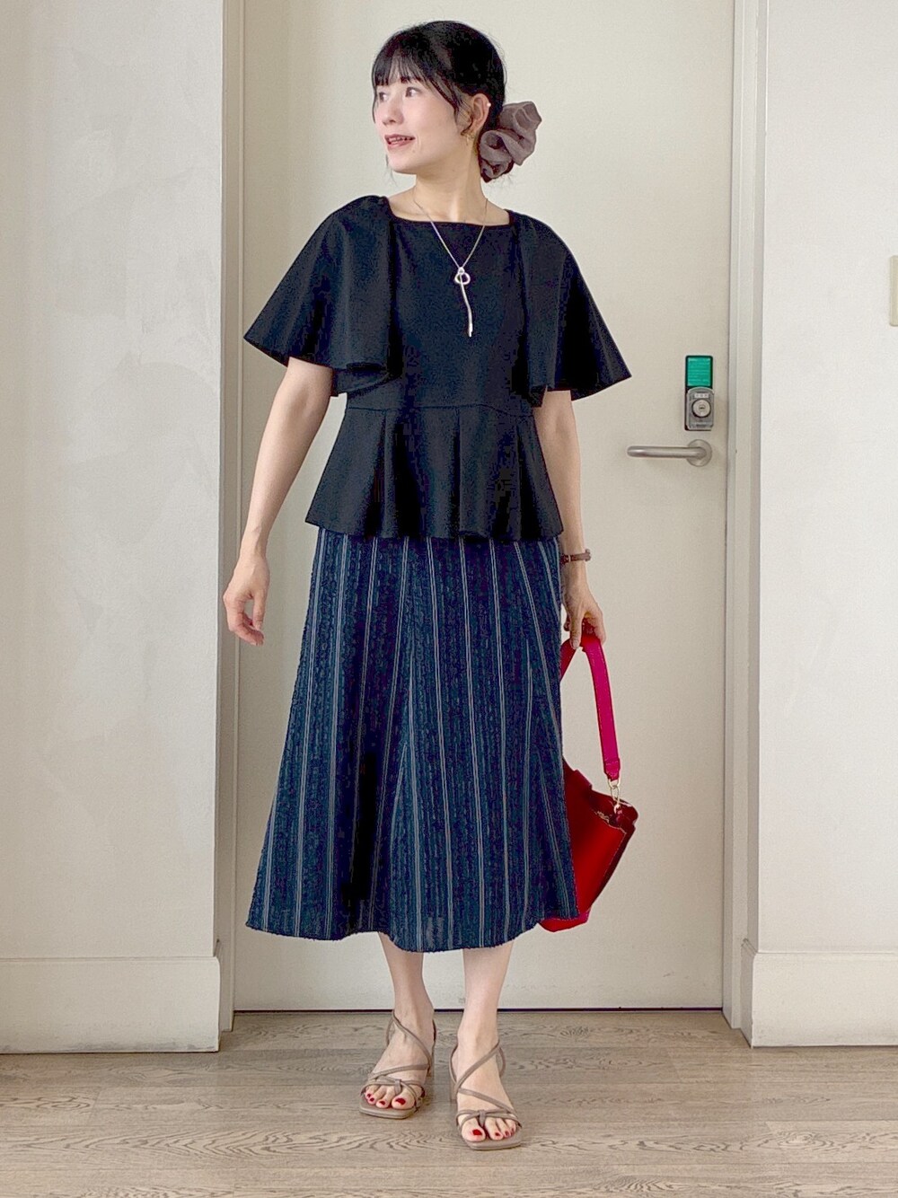 ブラック系のTシャツ/カットソー、ブルー系のスカート、レッド系のトートバッグを着用したレディースの夏コーディネートの5枚目の写真