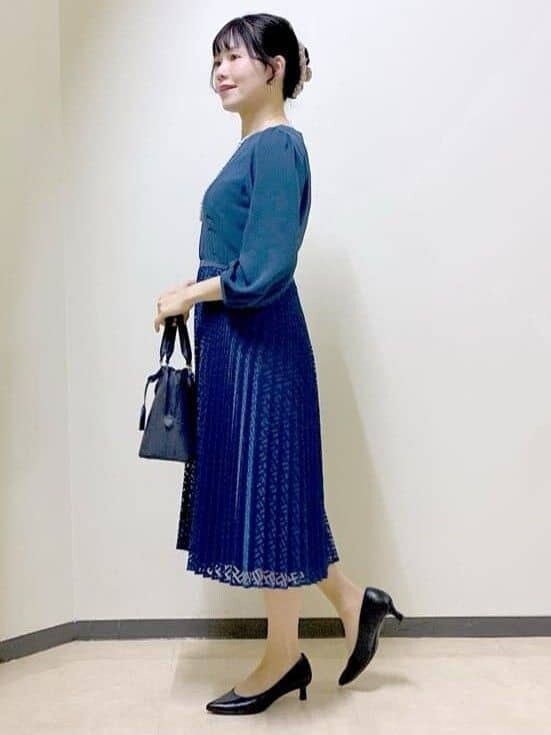 ブルー系のワンピース、ブルー系のトレンチコート、ブルー系のハンドバッグを着用したレディースの冬コーディネートの2枚目の写真