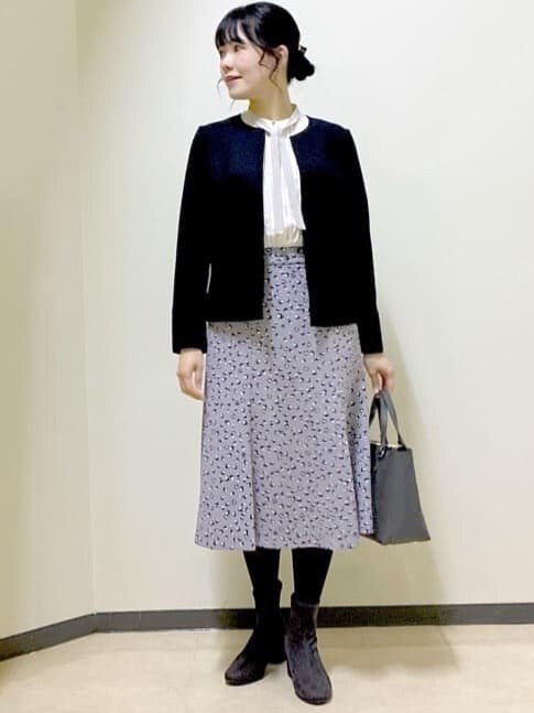 ホワイト系のシャツ/ブラウス、グレー系のスカート、ブラック系のノーカラージャケットを着用したレディースの冬コーディネートの10枚目の写真