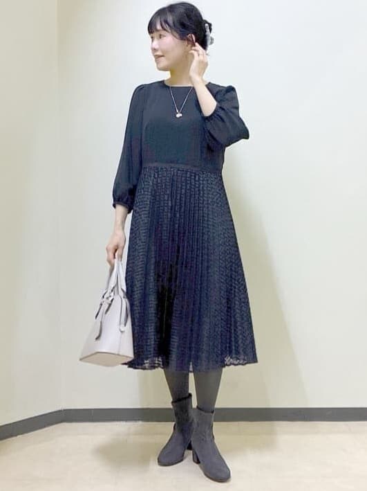 ブルー系のワンピース、グレー系のチェスターコート、ベージュ系のハンドバッグを着用したレディースの冬コーディネートの5枚目の写真