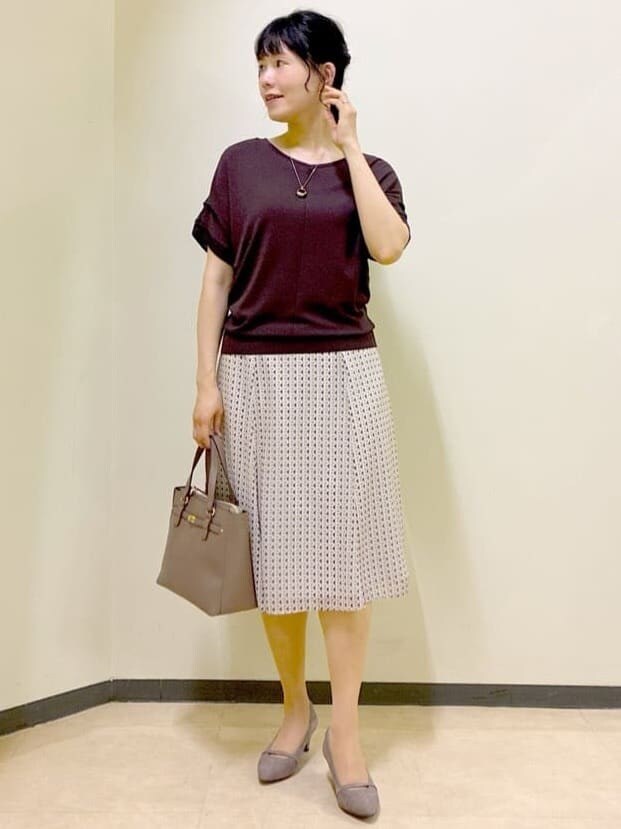 ブラウン系のニット/セーター、ベージュ系のスカート、レッド系のTシャツ/カットソーを着用したレディースの夏コーディネートの7枚目の写真