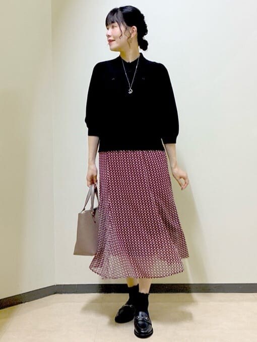 ブラック系のニット/セーター、グレー系のその他パンツ、レッド系のスカートを着用したレディースの秋コーディネートの9枚目の写真