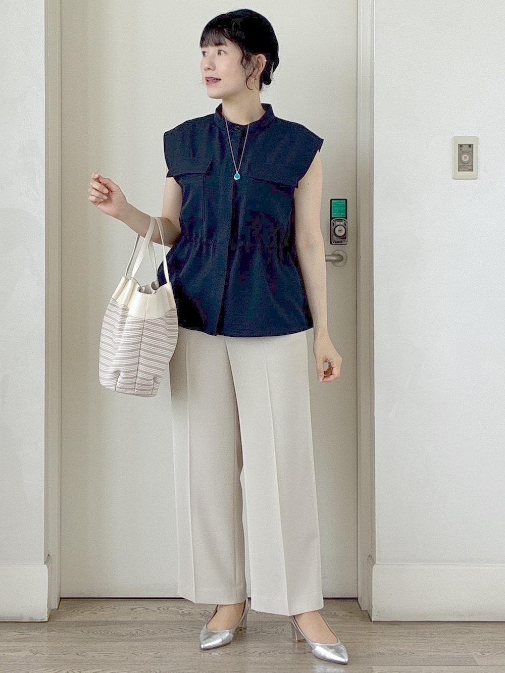 ブルー系のベスト、ベージュ系のその他パンツ、ベージュ系のトートバッグを着用したレディースの春コーディネートの10枚目の写真