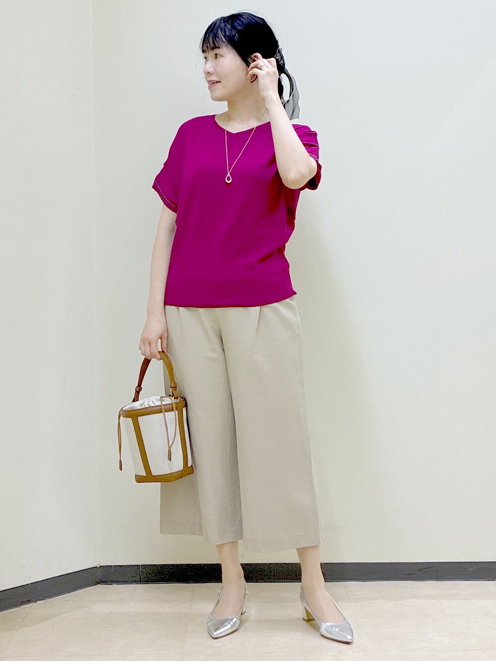 ピンク系のニット/セーター、ベージュ系のその他パンツ、イエロー系のショルダーバッグを着用したレディースの春コーディネートの6枚目の写真