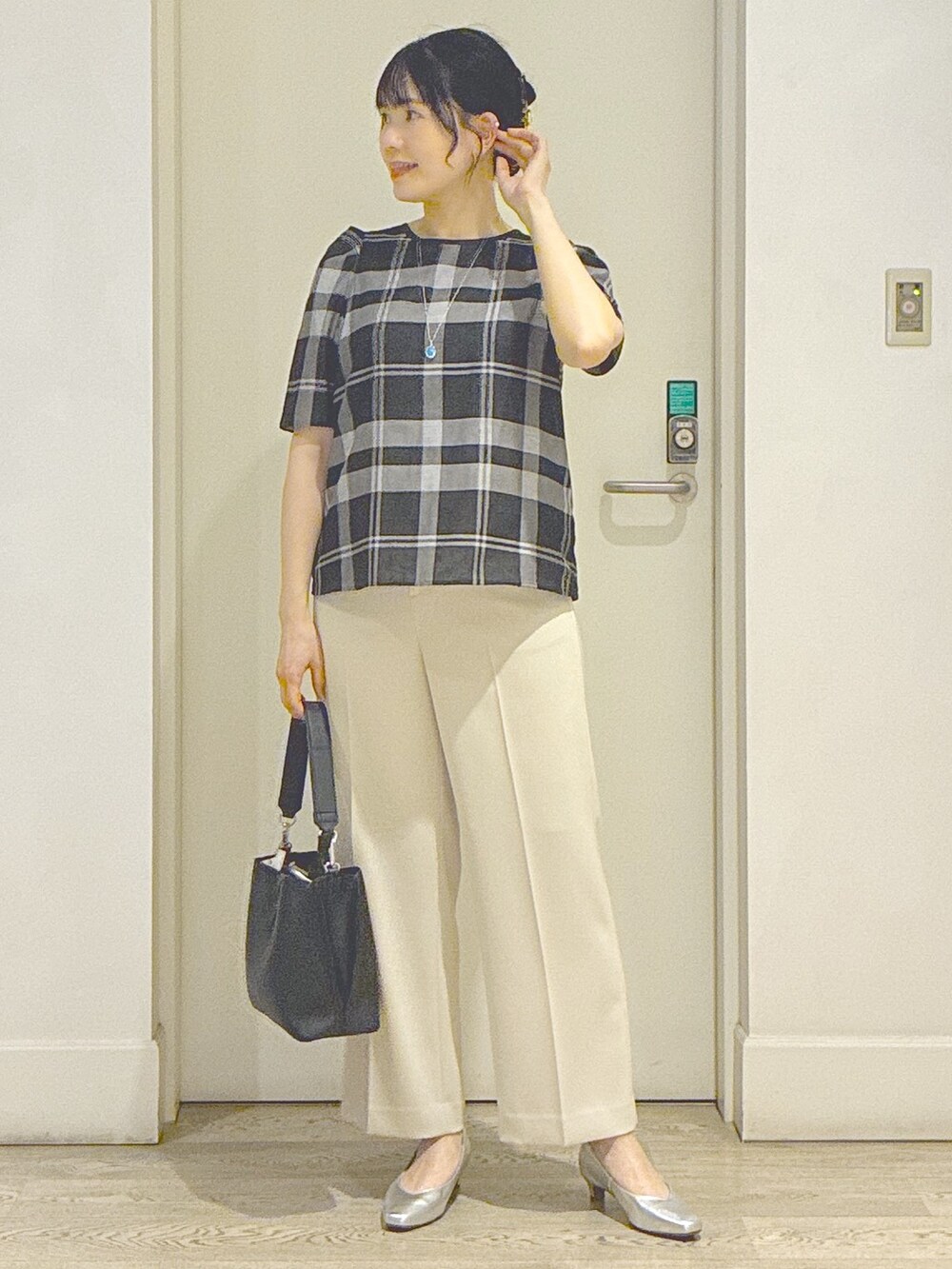 ベージュ系のその他パンツ、ブラック系のトートバッグ、ブルー系のネックレスを着用したレディースの夏コーディネートの5枚目の写真