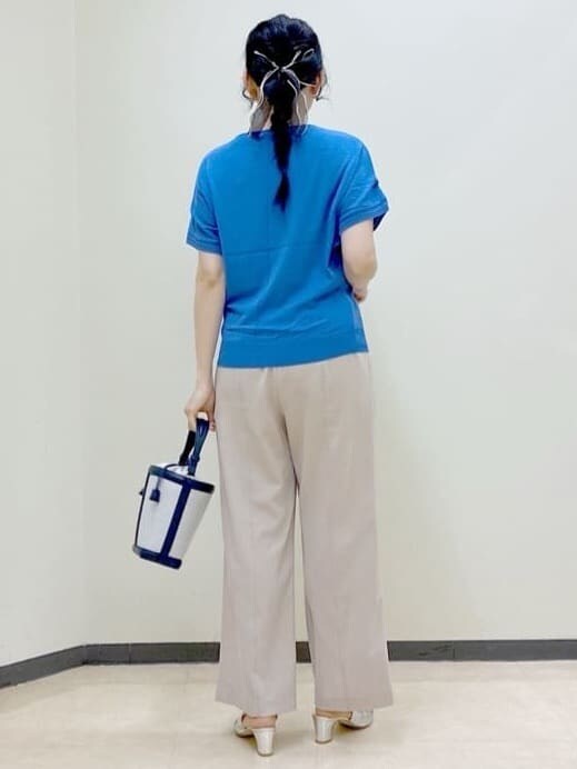 ベージュ系のその他パンツ、ブルー系のニット/セーター、ブルー系のショルダーバッグを着用したレディースの春コーディネートの3枚目の写真