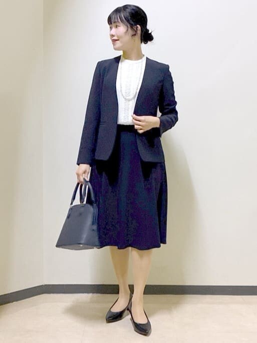 ブルー系のノーカラージャケット、ホワイト系のシャツ/ブラウス、ブルー系のスカートを着用したレディースの冬コーディネートの5枚目の写真