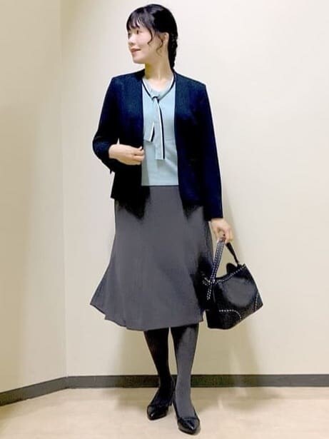ブルー系のノーカラージャケット、ブルー系のニット/セーター、グレー系のスカートを着用したレディースの秋コーディネートの8枚目の写真