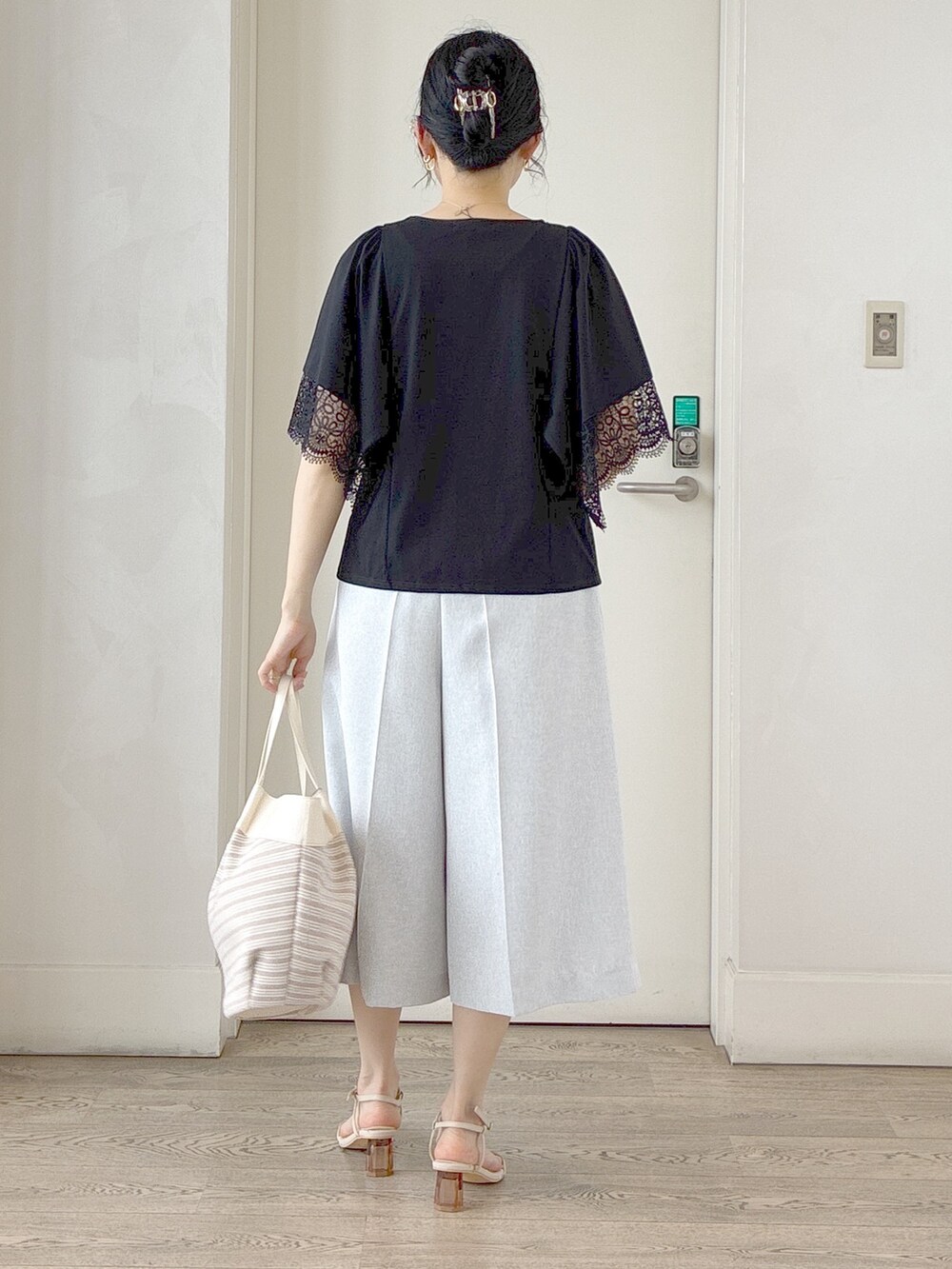 ブラック系のTシャツ/カットソー、グレー系のその他パンツ、ベージュ系のトートバッグを着用したレディースの夏コーディネートの3枚目の写真