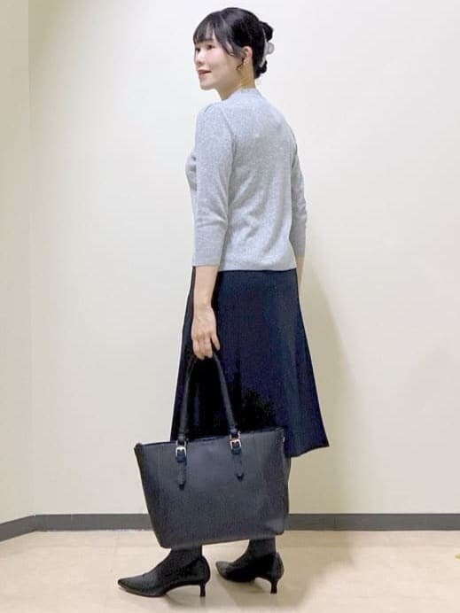 グレー系のニット/セーター、ブルー系のテーラードジャケット、ブルー系のスカートを着用したレディースの冬コーディネートの4枚目の写真
