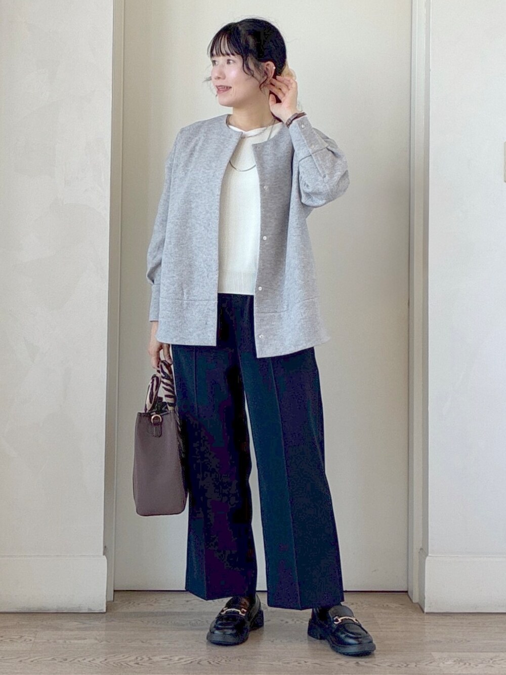 ブルー系のその他パンツ、ブラウン系のトートバッグ、シルバー系のネックレスを着用したレディースの秋コーディネートの7枚目の写真