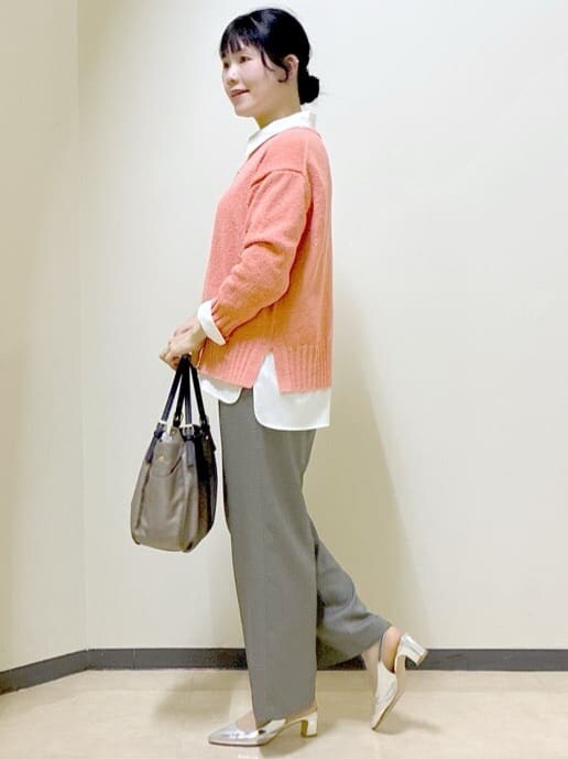 オレンジ系のニット/セーター、ホワイト系のシャツ/ブラウス、ベージュ系のその他パンツを着用したレディースの春コーディネートの2枚目の写真