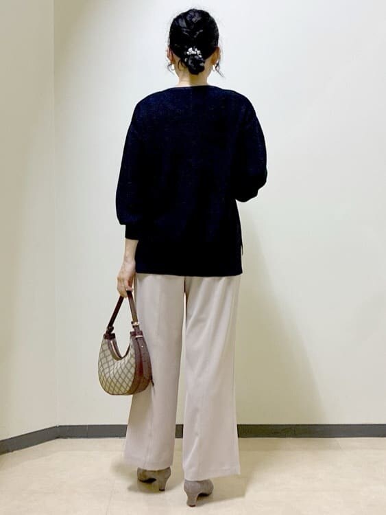 ブラック系のニット/セーター、ベージュ系のその他パンツ、イエロー系のショルダーバッグを着用したレディースの秋コーディネートの3枚目の写真