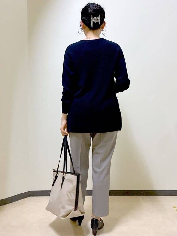 ブルー系のニット/セーター、ブラウン系のその他パンツ、ベージュ系のトートバッグを着用したレディースの春コーディネートの3枚目の写真