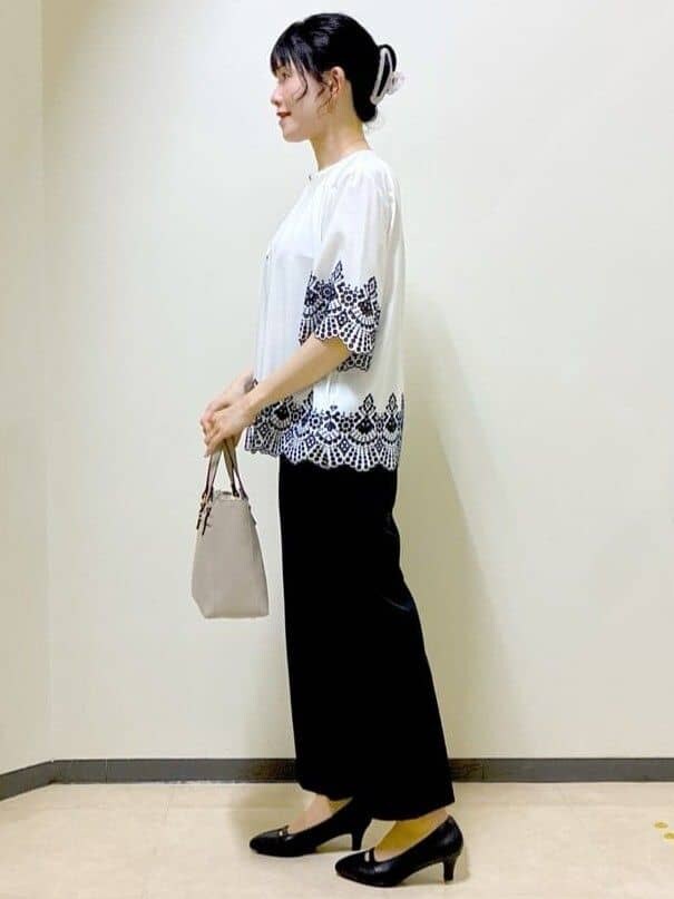 ホワイト系のシャツ/ブラウス、ブラック系のその他パンツ、ベージュ系のハンドバッグを着用したレディースの夏コーディネートの2枚目の写真