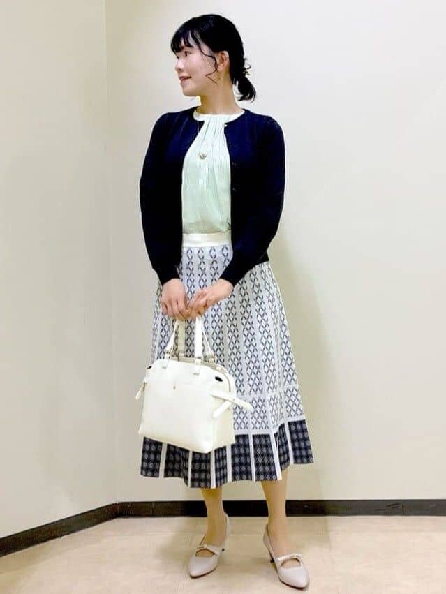 グリーン系のシャツ/ブラウス、ブルー系のカーディガン/ボレロ、ホワイト系のスカートを着用したレディースの春コーディネートの9枚目の写真