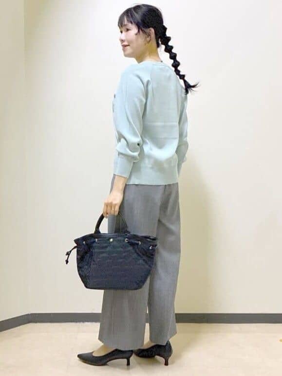 グリーン系のニット/セーター、グレー系のその他パンツ、ブラック系のトートバッグを着用したレディースの冬コーディネートの4枚目の写真