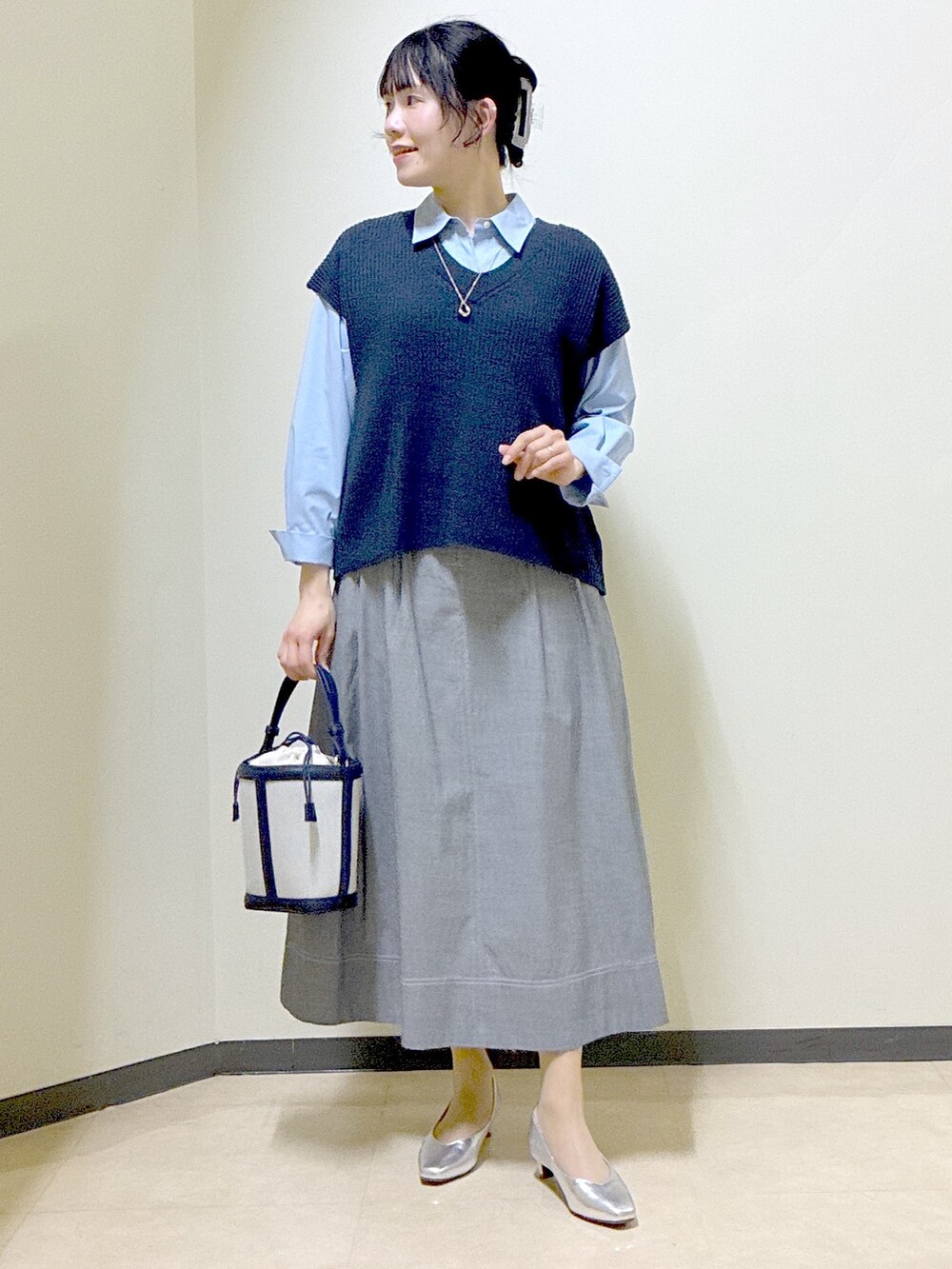 ブルー系のシャツ/ブラウス、ブルー系のニット/セーター、ブラック系のスカートを着用したレディースの春コーディネートの9枚目の写真