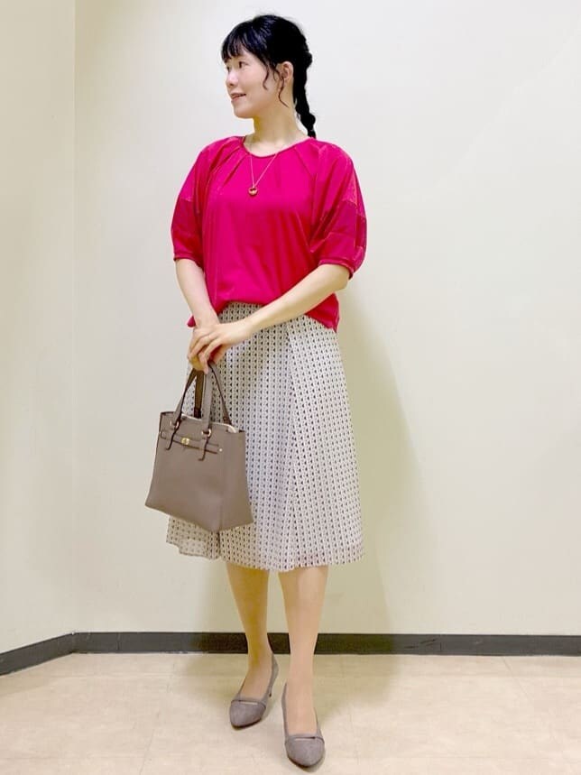 レッド系のTシャツ/カットソー、ベージュ系のスカート、ブラウン系のニット/セーターを着用したレディースの秋コーディネートの8枚目の写真
