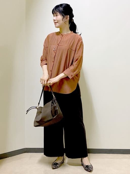 オレンジ系のシャツ/ブラウス、ブラック系のタンクトップ、ブラウン系のその他パンツを着用したレディースの秋コーディネートの5枚目の写真
