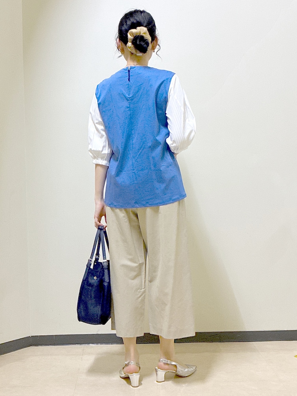 ブルー系のTシャツ/カットソー、ベージュ系のその他パンツ、ブルー系のショルダーバッグを着用したレディースの春コーディネートの3枚目の写真