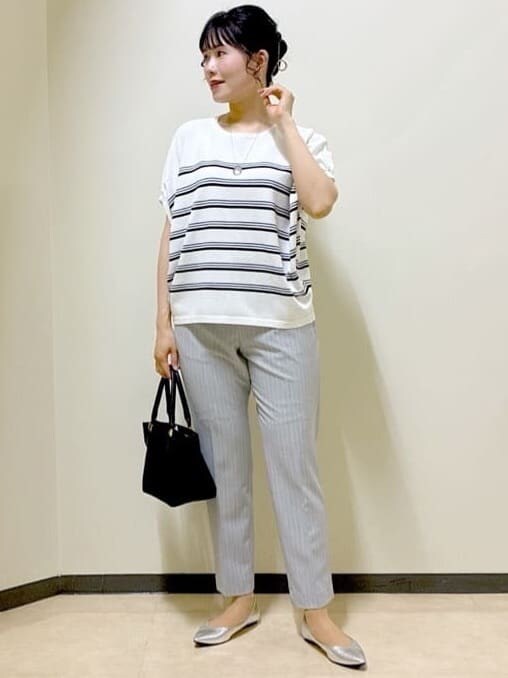 ホワイト系のニット/セーター、グレー系のその他パンツ、ブラウン系のスカートを着用したレディースの夏コーディネートの7枚目の写真