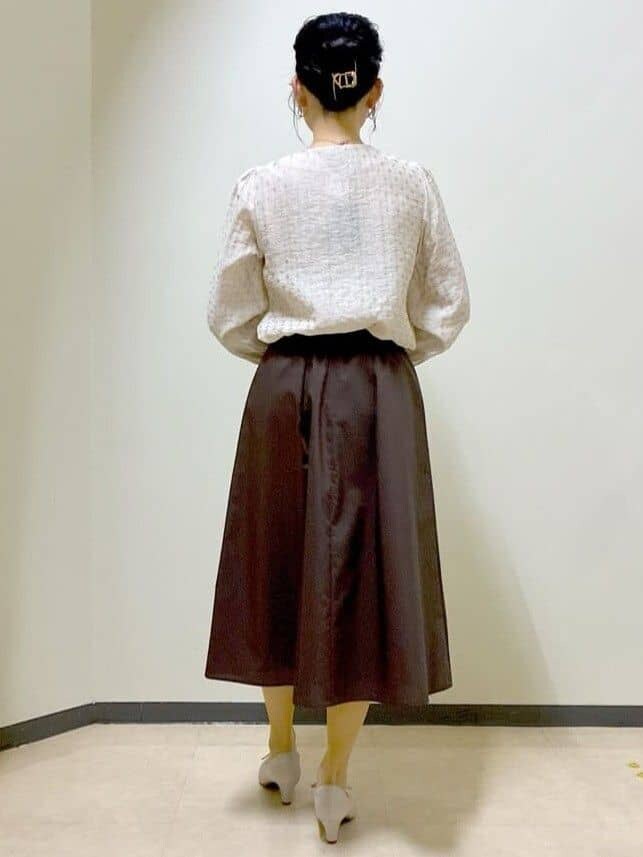 ベージュ系のシャツ/ブラウス、ブラウン系のスカート、ベージュ系のトートバッグを着用したレディースの春コーディネートの3枚目の写真