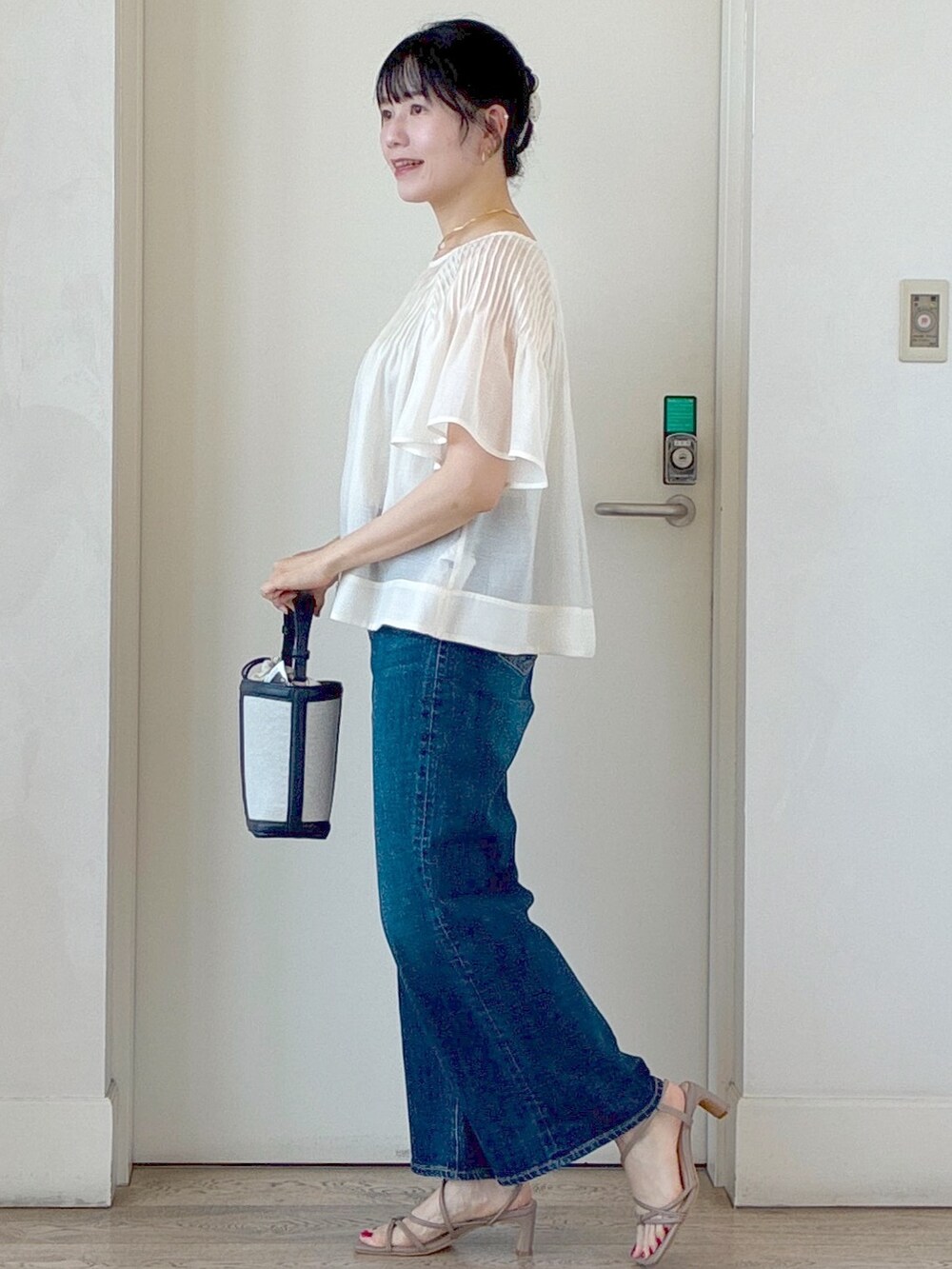 ホワイト系のシャツ/ブラウス、ベージュ系のタンクトップ、ブルー系のデニムパンツを着用したレディースの夏コーディネートの2枚目の写真