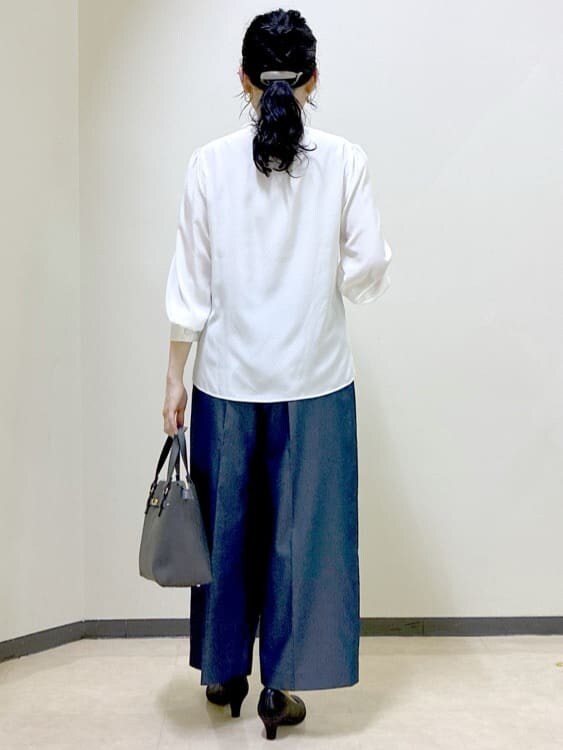 ホワイト系のシャツ/ブラウス、ブラック系のベスト、ブルー系のその他パンツを着用したレディースの秋コーディネートの3枚目の写真