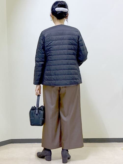 ブラック系のダウンジャケット/コート、ブラック系のニット/セーター、ブルー系のTシャツ/カットソーを着用したレディースの冬コーディネートの3枚目の写真