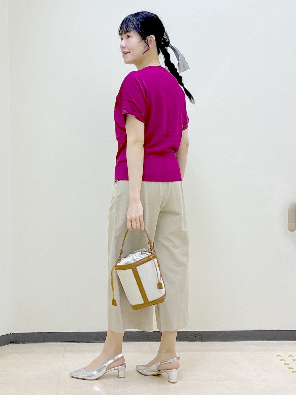 ピンク系のニット/セーター、ベージュ系のその他パンツ、イエロー系のショルダーバッグを着用したレディースの春コーディネートの4枚目の写真