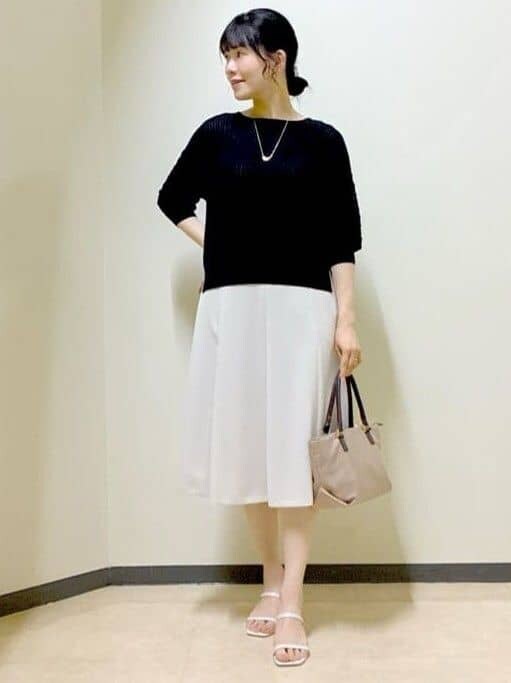 ブラック系のニット/セーター、ベージュ系のスカート、ベージュ系のトートバッグを着用したレディースの夏コーディネートの7枚目の写真