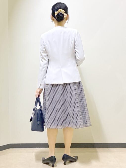 グレー系のノーカラージャケット、ブルー系のシャツ/ブラウス、ブルー系のスカートを着用したレディースの冬コーディネートの3枚目の写真