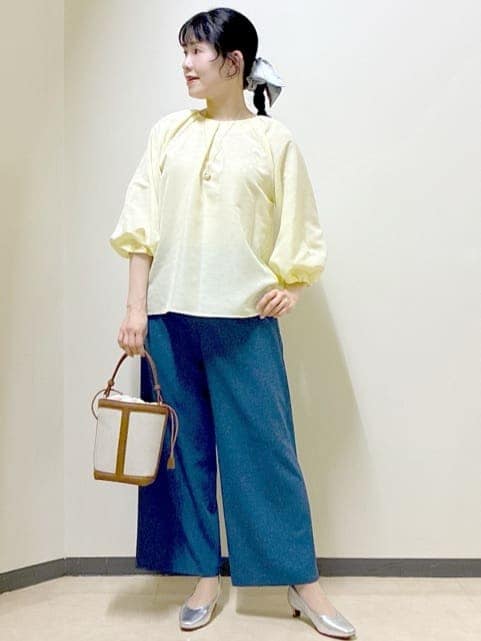 イエロー系のシャツ/ブラウス、シルバー系のパンプス、ブルー系のその他パンツを着用したレディースの冬コーディネートの9枚目の写真