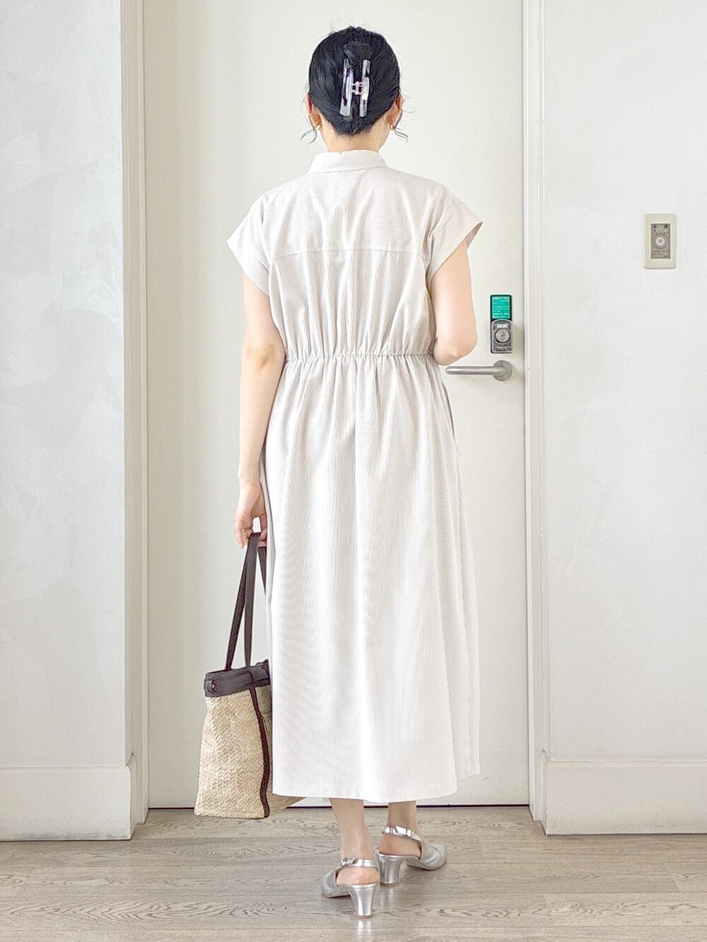 ベージュ系のワンピース、イエロー系のトートバッグ、ホワイト系のネックレスを着用したレディースの夏コーディネートの3枚目の写真