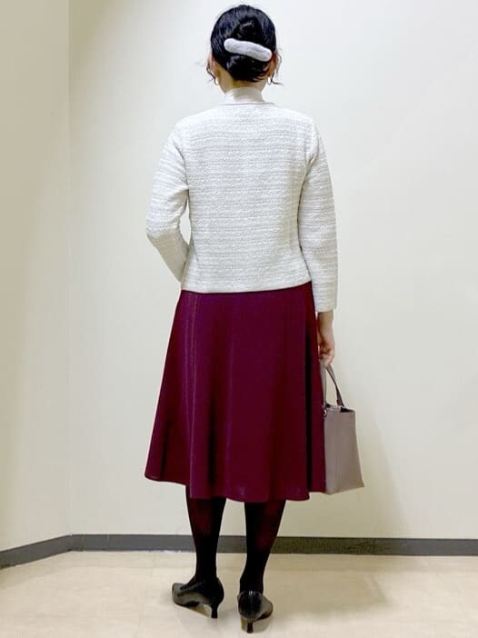 グレー系のカーディガン/ボレロ、ベージュ系のニット/セーター、レッド系のスカートを着用したレディースの冬コーディネートの3枚目の写真