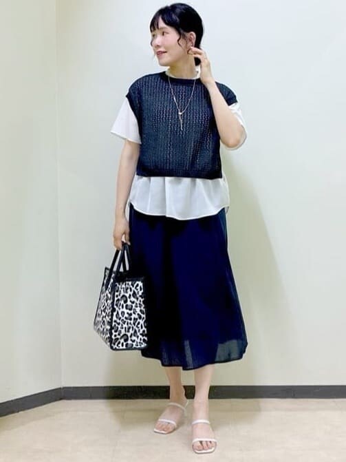 ベージュ系のシャツ/ブラウス、ブラック系のニット/セーター、ブルー系のスカートを着用したレディースの夏コーディネートの5枚目の写真