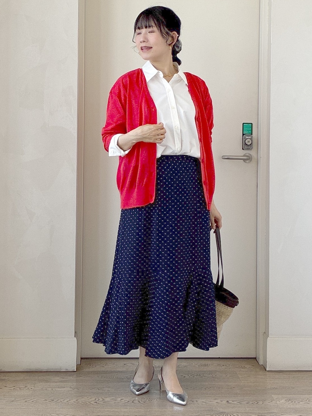 オレンジ系のカーディガン/ボレロ、ホワイト系のシャツ/ブラウス、ブルー系のスカートを着用したレディースの秋コーディネートの7枚目の写真