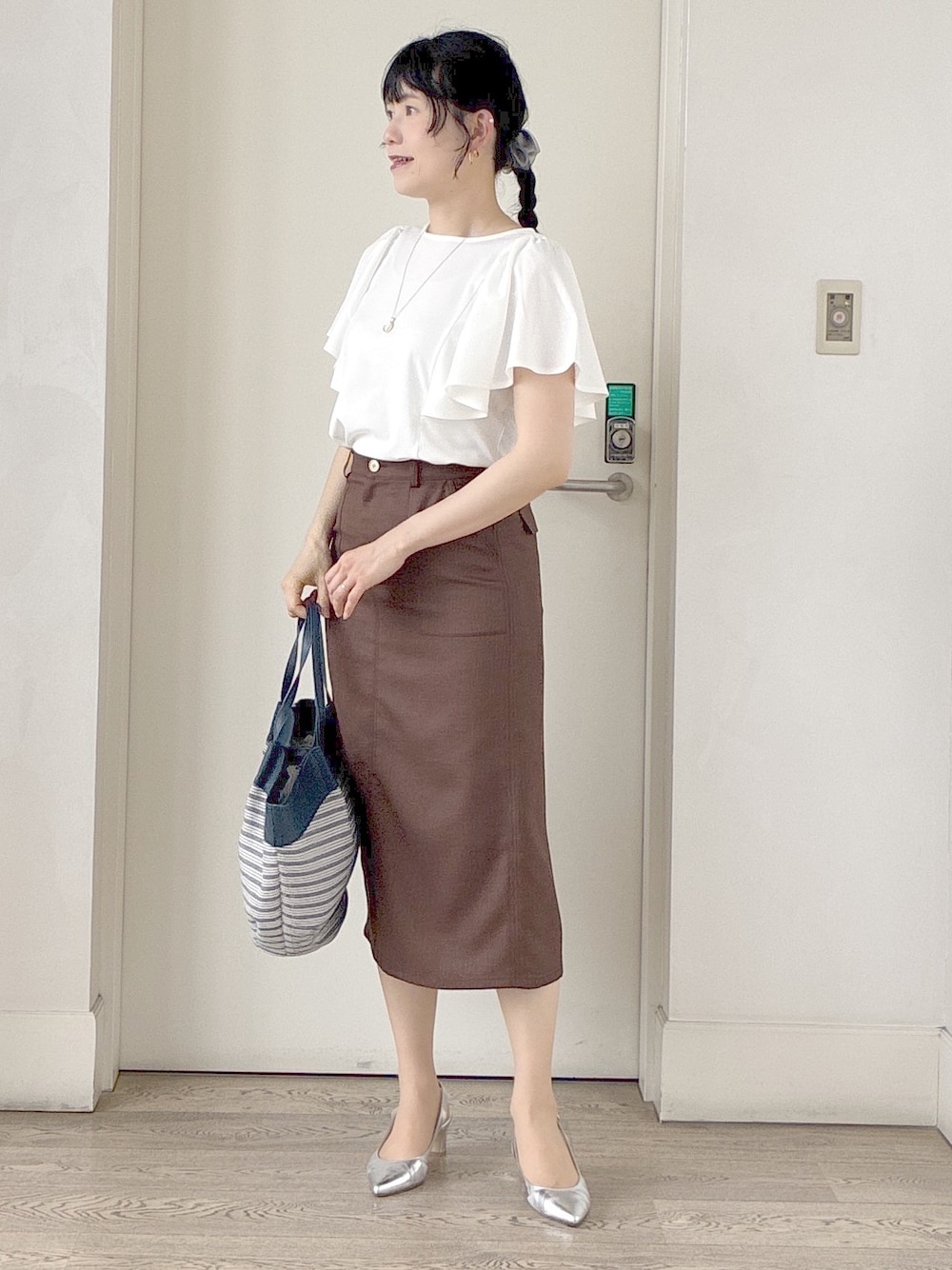 ホワイト系のTシャツ/カットソー、ブラック系のブルゾン、ブラウン系のスカートを着用したレディースの夏コーディネートの8枚目の写真