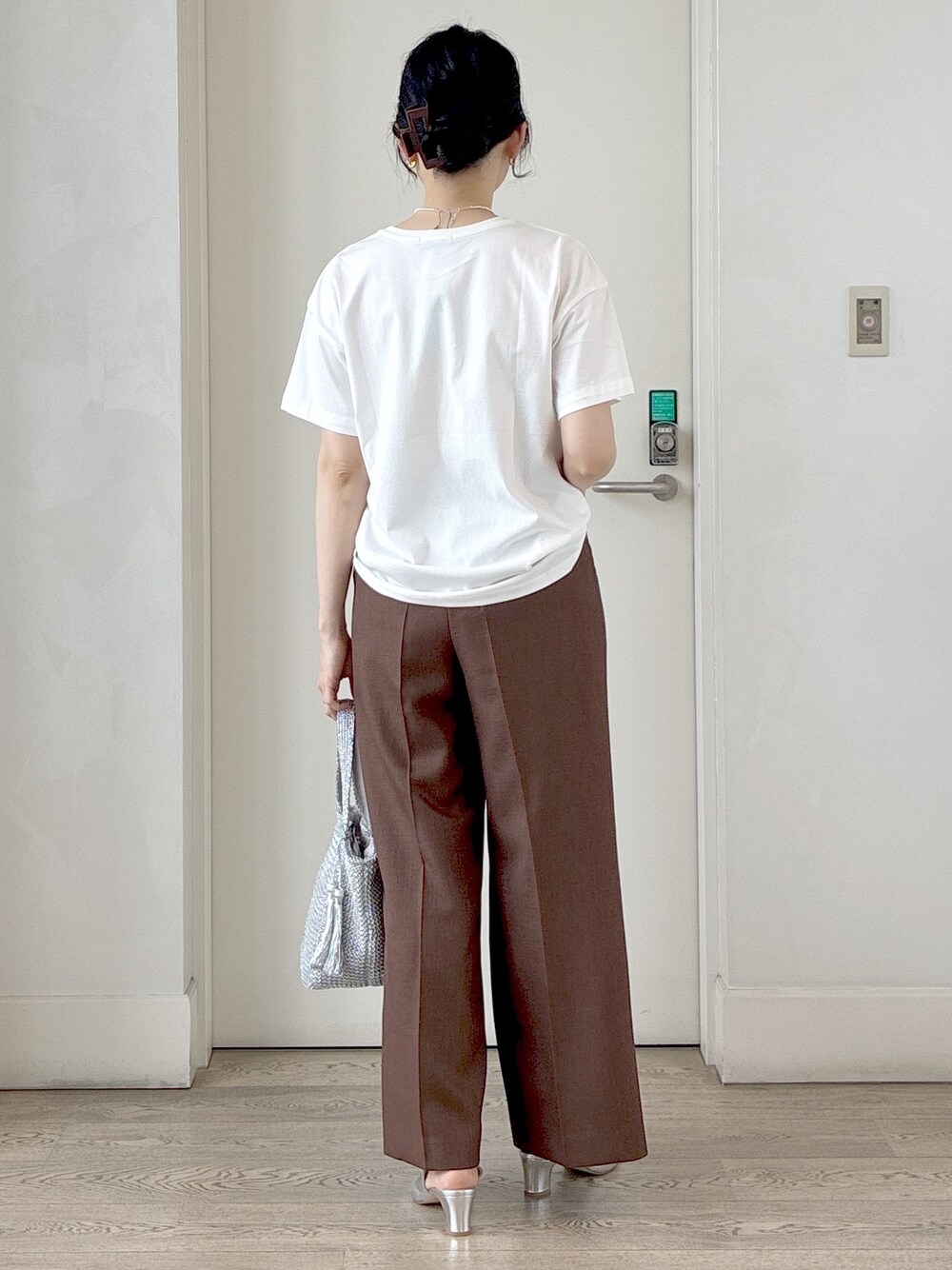 ホワイト系のTシャツ/カットソー、ブラック系のベスト、ブラウン系のその他パンツを着用したレディースの春コーディネートの3枚目の写真