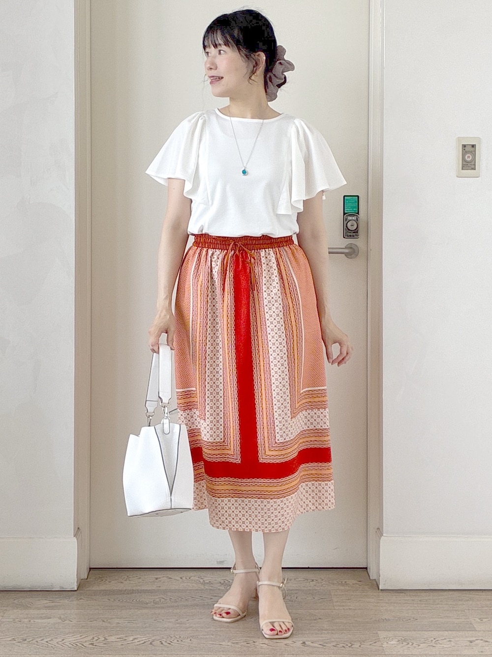 ホワイト系のTシャツ/カットソー、オレンジ系のスカート、ホワイト系のトートバッグを着用したレディースの夏コーディネートの4枚目の写真