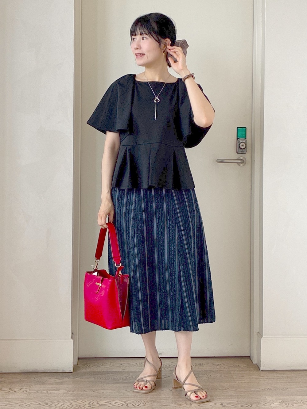 ブラック系のTシャツ/カットソー、ブルー系のスカート、レッド系のトートバッグを着用したレディースの夏コーディネートの6枚目の写真