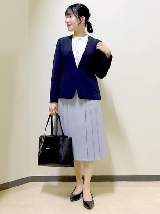 ブルー系のノーカラージャケット、ホワイト系のシャツ/ブラウス、ブラック系のトートバッグを着用したレディースの春コーディネートの7枚目の写真