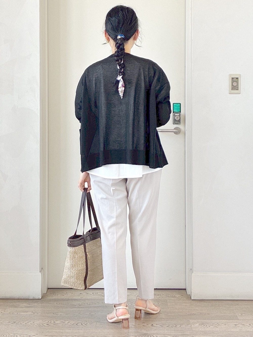 ブラック系のカーディガン/ボレロ、ホワイト系のTシャツ/カットソー、ベージュ系のタンクトップを着用したレディースの夏コーディネートの3枚目の写真