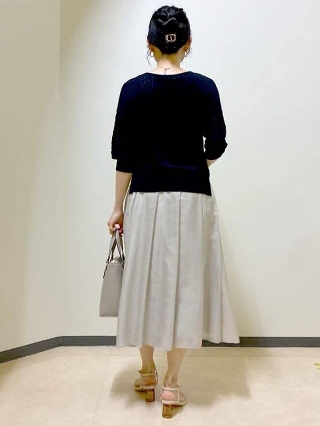 ブラック系のニット/セーター、ベージュ系のスカート、ブラウン系のスカートを着用したレディースの夏コーディネートの3枚目の写真